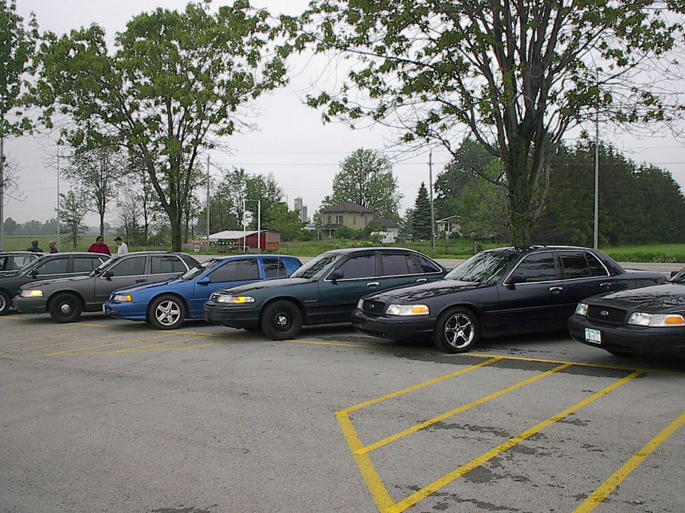 Several dark sedans parked in a lot.