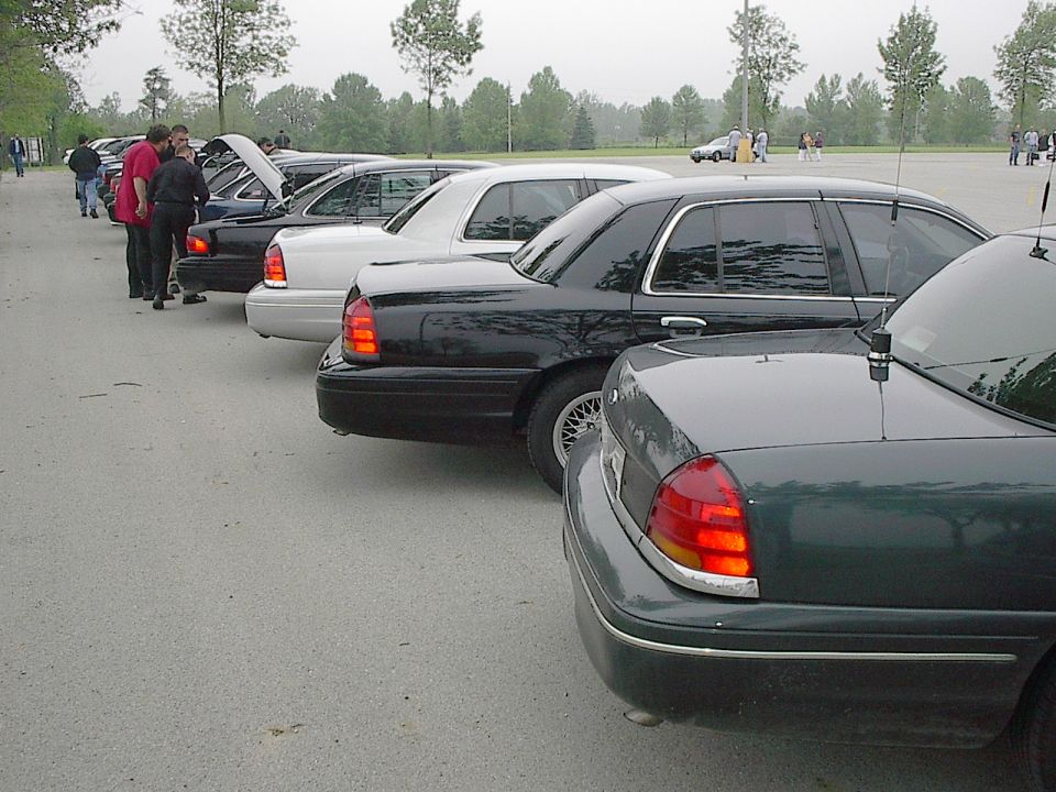 Rear quarter panel and taillight of a dark green sedan parked in a lot.