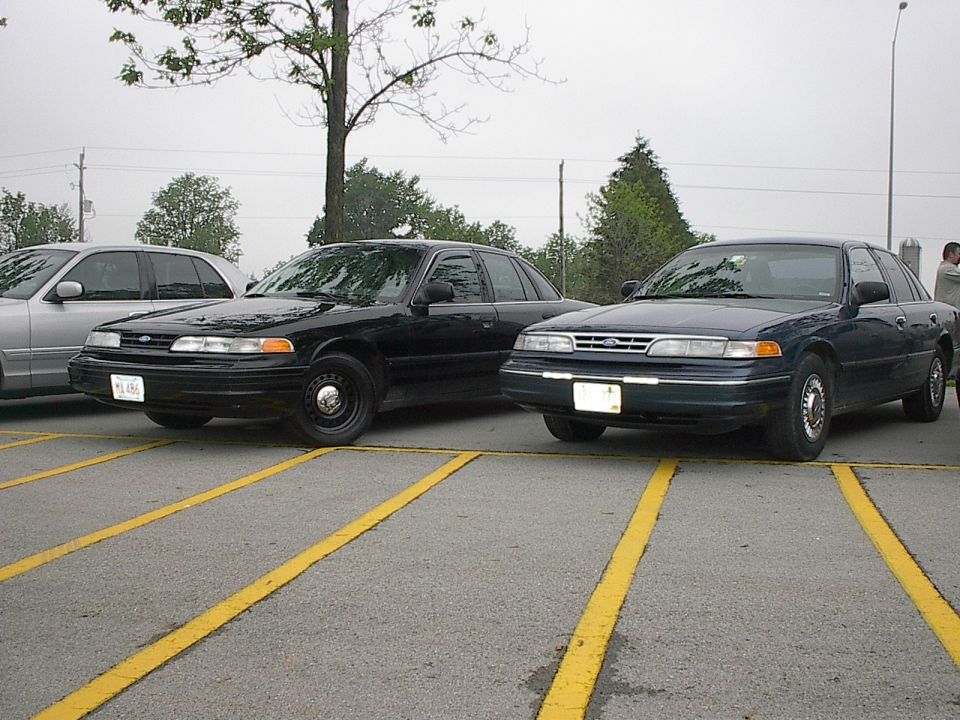 Two sedans parked side-by-side in a parking lot.