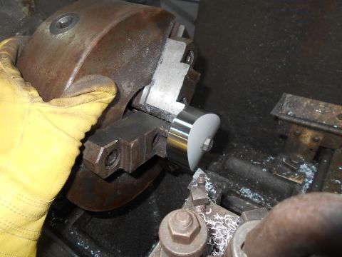1992 Ford Bronco - A gloved hand is holding a metal part against a lathe chuck. Metal shavings are visible on the machine.