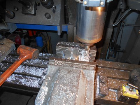 1992 Ford Bronco - A milling machine is cutting a metal part, creating a pile of metal shavings on the machine's table. A wooden mallet rests on the table nea…