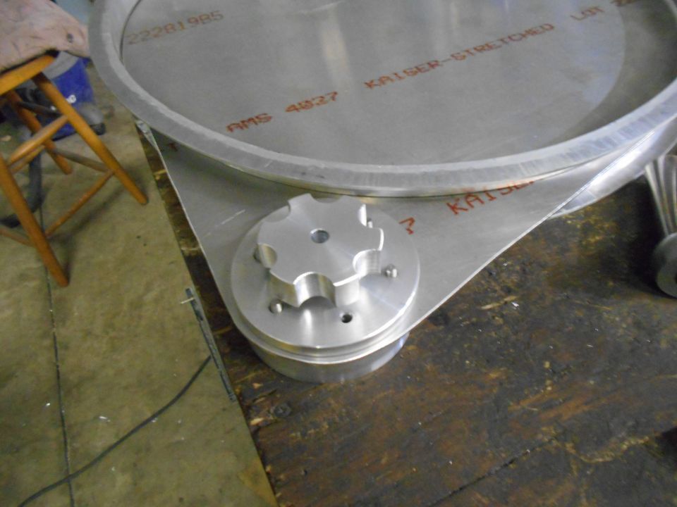 Metal component with star-shaped knob and stamped text on a wooden surface.