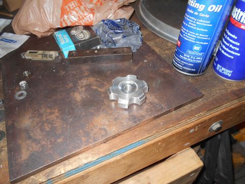 1992 Ford Bronco - A metal knob with a threaded hole sits on a rusty metal plate on a workbench. Various tools and supplies, including cans of cutting oil and…