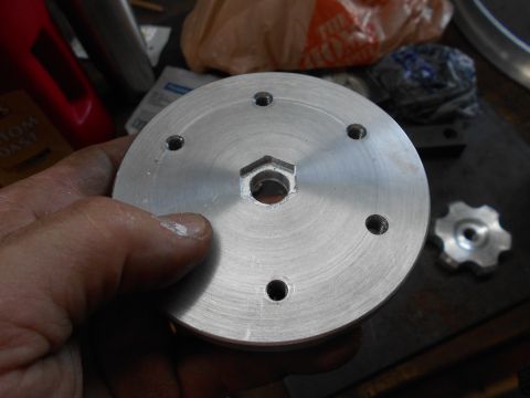 1992 Ford Bronco - A hand holds a circular metal part with a hexagonal hole in the center and six smaller holes around the perimeter. Another smaller, gear-sh…