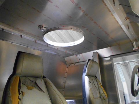 1992 Ford Bronco - Interior view of a vehicle showing two worn seats and the metal ceiling with a circular vent. The ceiling has visible text printed on it.