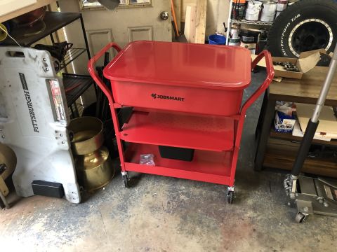 1995 Ford Bronco - A red utility cart with three shelves is shown in a garage setting. The cart has a large red basin on top and is positioned next to a large…