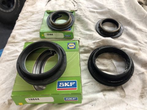 1995 Ford Bronco - Two SKF oil seals are displayed on a white cloth. One seal is in its green SKF box with the part number 13144 visible. Another larger seal…