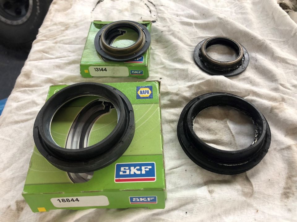 Two SKF oil seals, one in a box labeled 13144 and another in a box labeled 18844, on a white cloth.