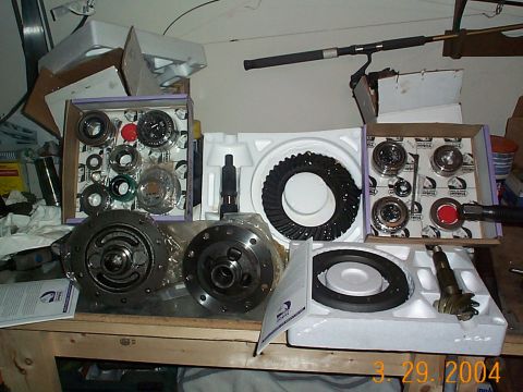 1992 Ford Bronco - Various differential components, including ring gears and bearings, are organized on a wooden surface.
