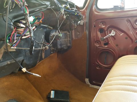 1978 Ford Bronco - The interior of a 1978 Ford Bronco shows exposed wiring and brown carpeting.