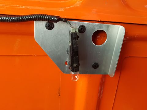 1978 Ford Bronco - A custom light fixture is mounted to an orange vehicle's body with a metal bracket and wiring.