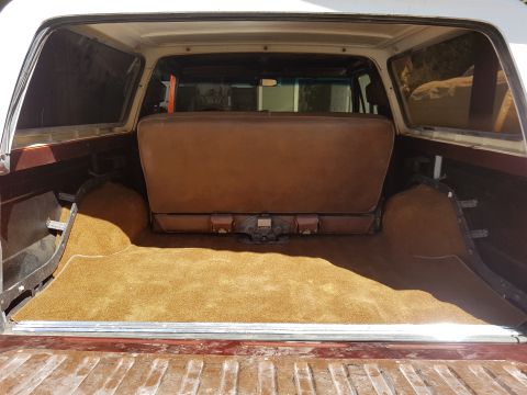 1978 Ford Bronco - The cargo area of a 1978 Ford Bronco features brown upholstery and carpeting, with a visible tow hitch.