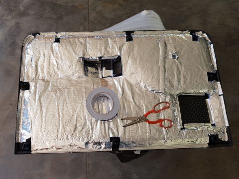 1978 Ford Bronco - Sound deadening material applied to a car door panel, with tools ready for installation.