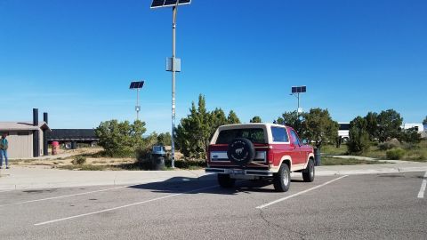 1985 Ford Bronco - This 1985 Ford Bronco is parked in a lot with solar panels visible in the background.