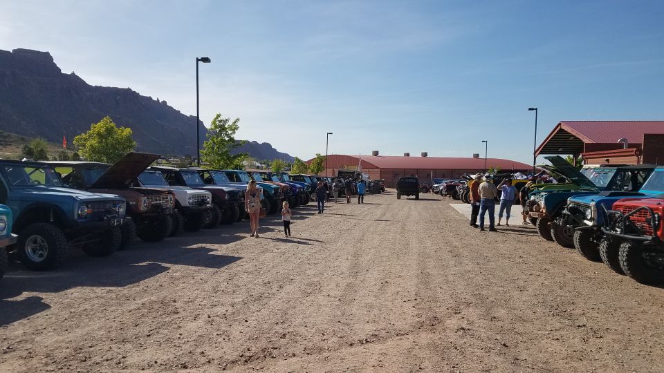 Line of Ford Broncos parked in a lot with mountains in the background