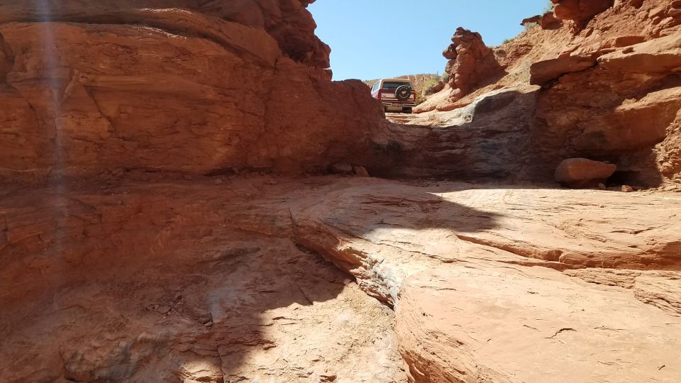 Rear view of an SUV on a narrow, rocky desert trail