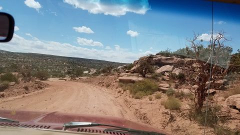 1985 Ford Bronco - Driving through a rocky, arid landscape on a sunny day.