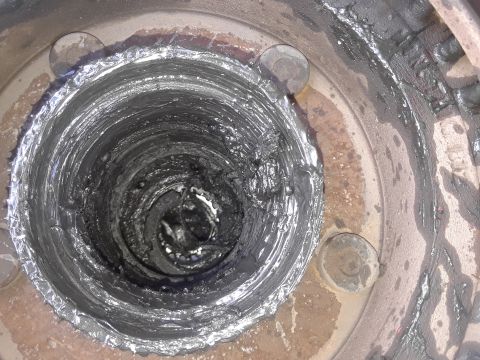 1985 Ford Bronco - Close-up view of wheel bearing grease packed into a hub assembly, showing signs of wear and contamination.