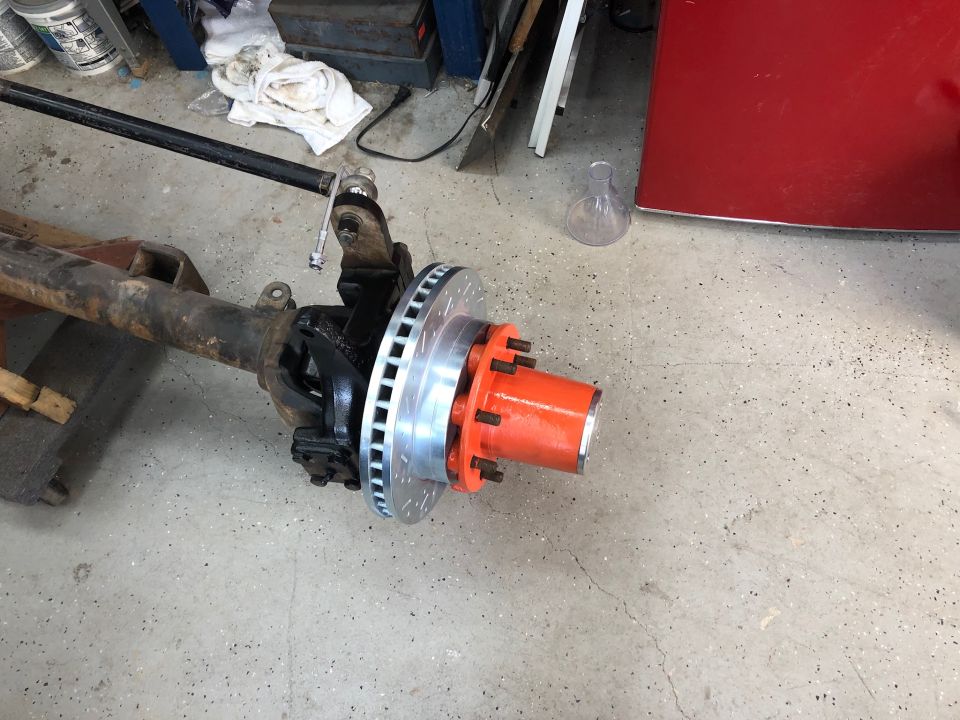 Front axle assembly with orange hub and disc brake rotor
