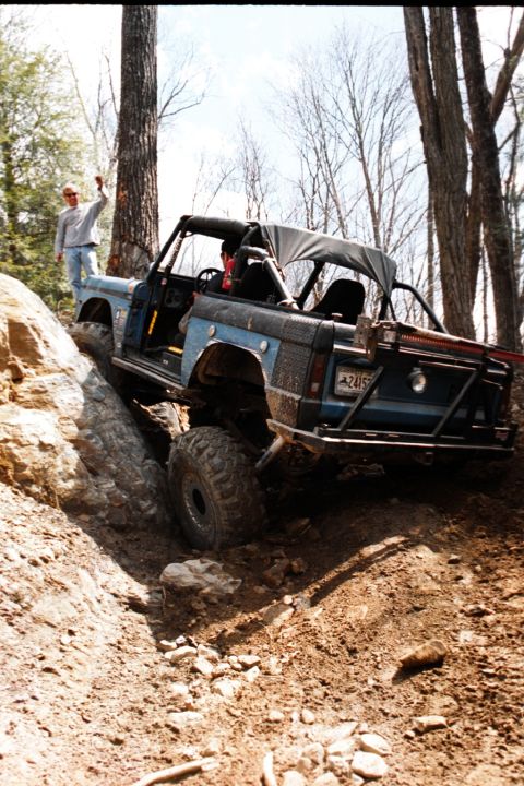 1976 Ford Bronco - A modified 1976 Ford Bronco navigates a steep, rocky incline during an off-road excursion.