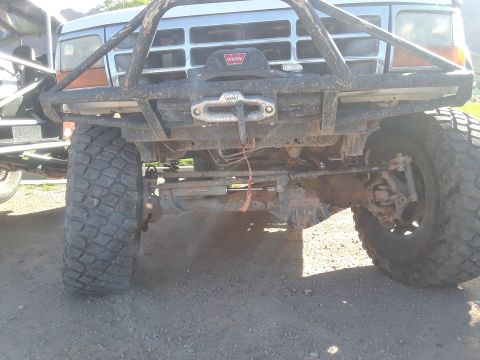 1985 Ford Bronco - Front view of a heavily modified Ford F-Series truck, likely from the late 1980s or early 1990s, a prominent winch and brush guard.