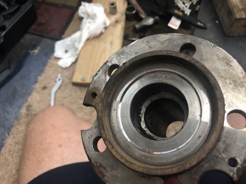 1995 Ford Bronco - A worn wheel hub assembly is held up, showing signs of damage and needing replacement.