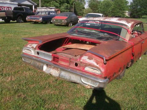 1960 Ford Starliner - Rear view of a weathered 1960 Ford Starliner, showing its iconic tail fins and chrome bumper.