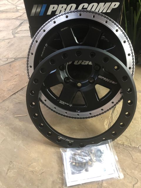 1992 Jeep Wrangler - Pro Comp wheels and hardware are displayed on a stone patio, with one wheel partially obscuring another.