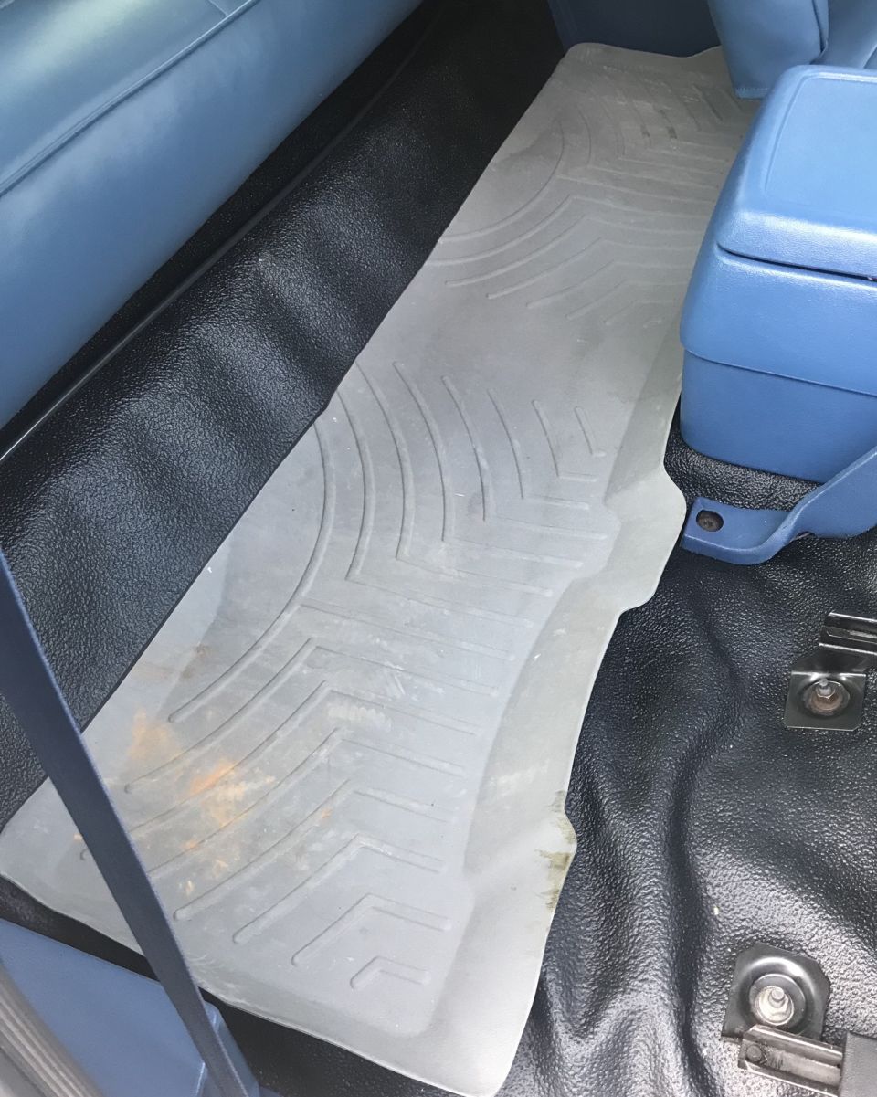 Gray WeatherTech floor mat on black carpet with blue interior trim and center console