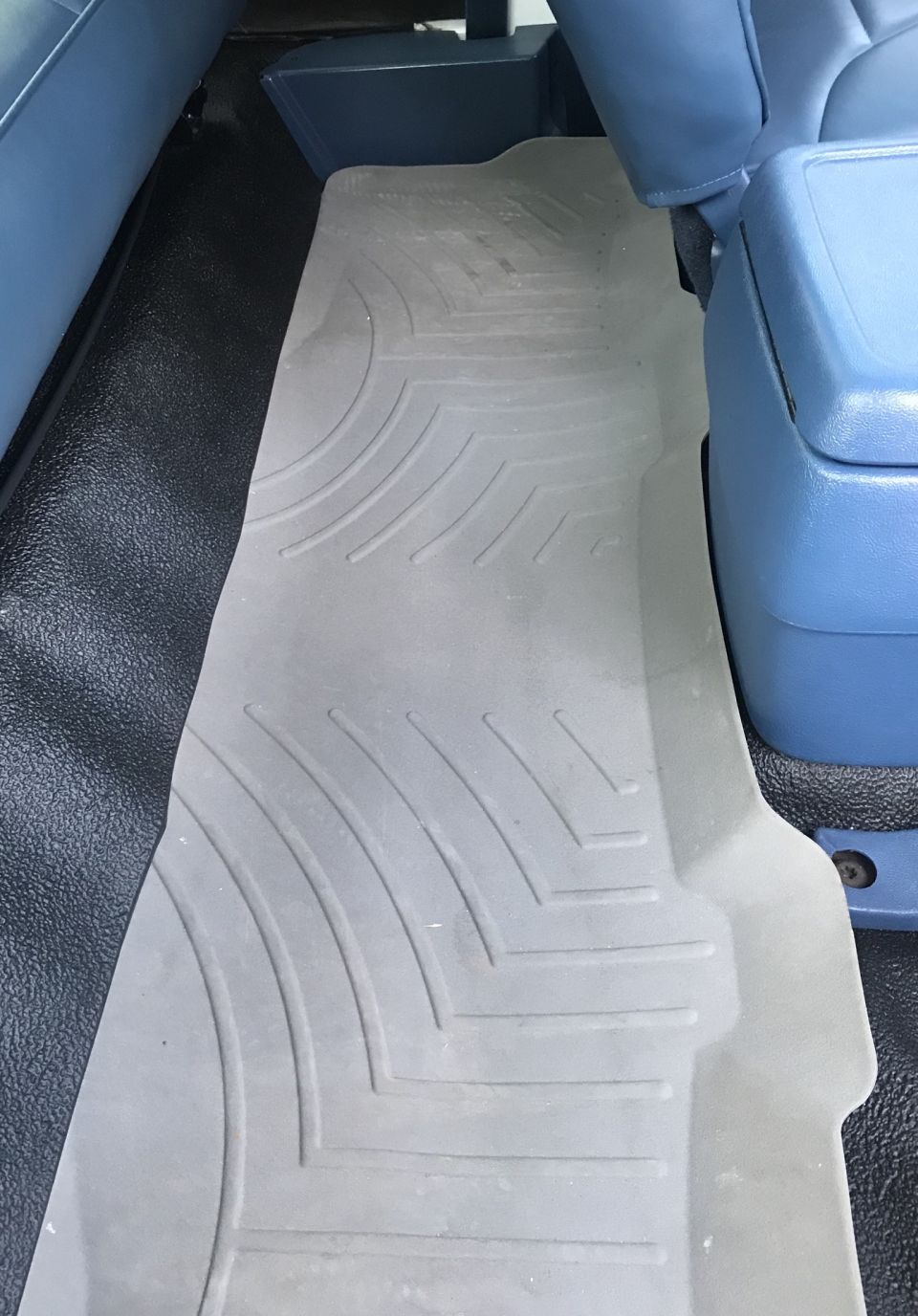 Gray WeatherTech floor mats in a vehicle's interior, covering the floor behind the front seats