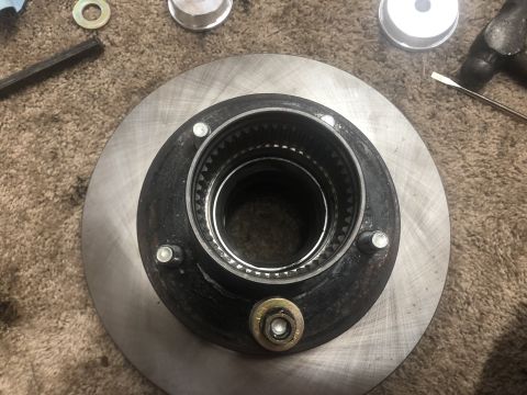 1995 Ford Bronco - Close-up of a brake rotor and hub assembly with various tools scattered around.