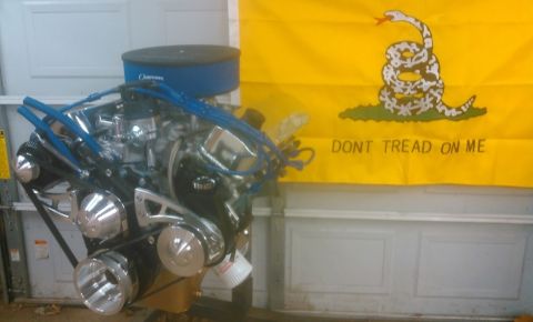 1978 Ford Bronco - Custom engine with chrome components and blue spark plug wires displayed in front of a Gadsden flag.