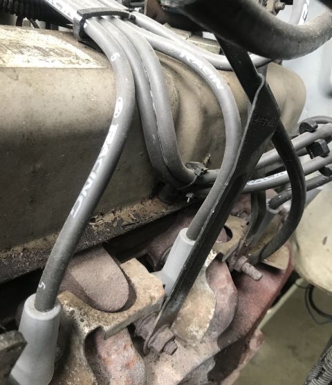 1995 Ford Bronco - Close-up view of engine spark plug wires and components, showing signs of wear and dirt.