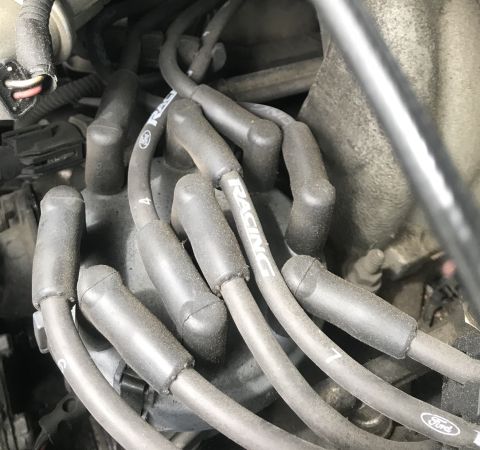 1995 Ford Bronco - Close-up view of engine spark plug wires, some of which are labeled 'RACING'.