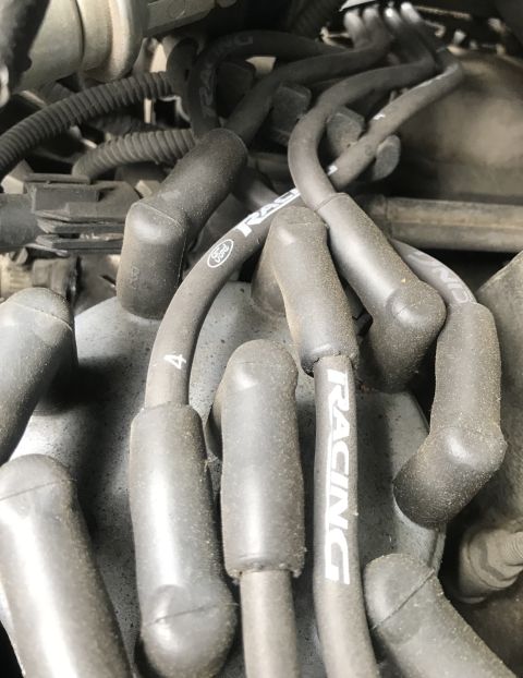 1995 Ford Bronco - Close-up of engine spark plug wires, one shows a Ford logo and 'RACING' text.