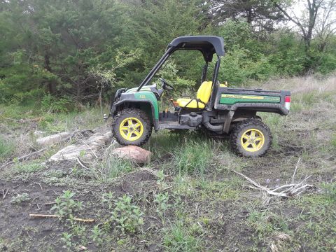 1994 Ford Bronco - This utility vehicle is parked on a muddy, grassy area with some rocks and fallen branches.