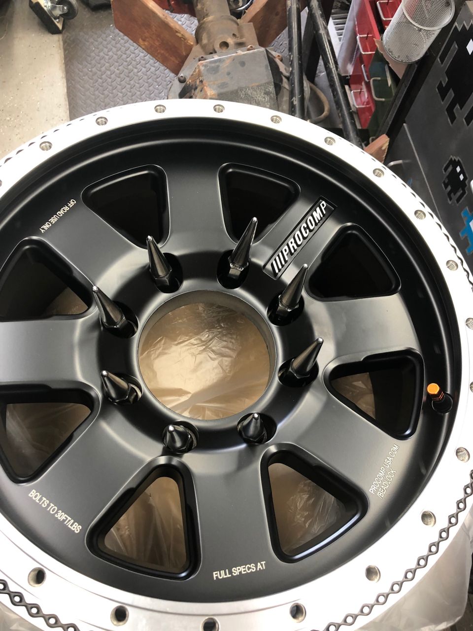 Pro Comp wheel with spike lug nuts and "OFF ROAD USE ONLY" text