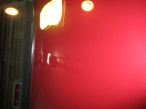 2004 Ford Crown Victoria - Close-up of a red car door, showing reflections and a detail cloth.