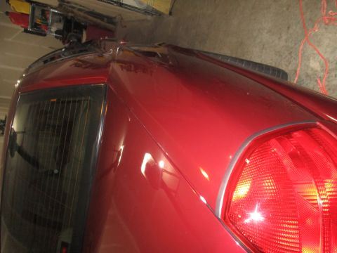 2004 Ford Crown Victoria - Close-up of a red vehicle's rear section, showing the taillight and part of the bodywork.