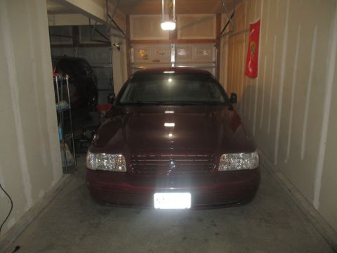 2004 Ford Crown Victoria - A maroon sedan is parked inside a garage, facing the camera.