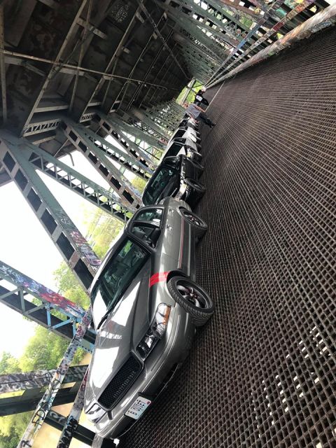 2004 Ford Crown Victoria - Several Ford Crown Victorias are lined up on a bridge with a metal grate deck.