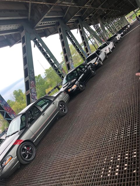 2004 Ford Crown Victoria - Multiple Ford Crown Victoria police cars are lined up on a bridge with a metal grate surface.