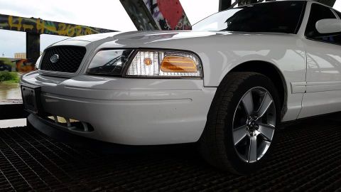 2004 Ford Crown Victoria - Front corner view of a white 2004 Ford Crown Victoria parked under a bridge.