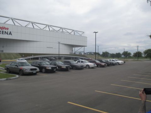 2004 Ford Crown Victoria - A row of Ford Crown Victoria police interceptors are parked in a lot outside an arena.