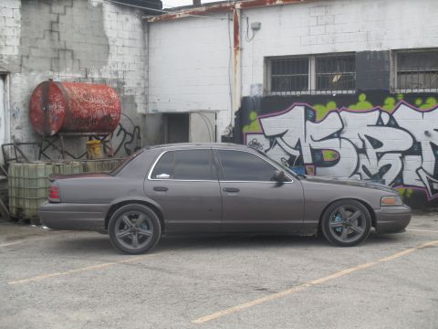 2004 Ford Crown Victoria - Side view of a gray Ford Crown Victoria parked outdoors.