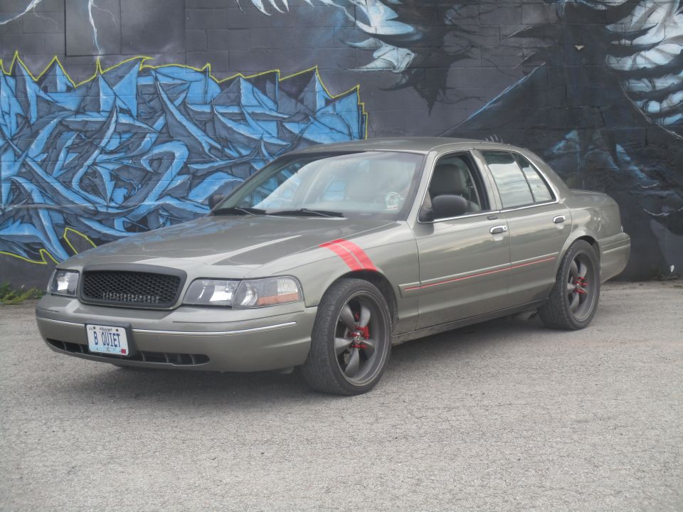 Gray sedan with red racing stripes on fender and door trim, black grille, custom wheels