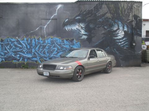 2004 Ford Crown Victoria - 2004 Ford Crown Victoria parked in front of a large dragon graffiti mural.