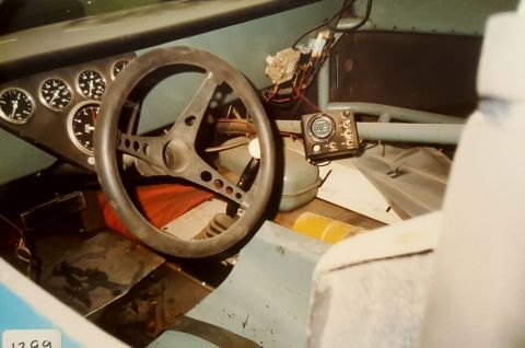 1973 Ford Mustang - The interior of a car displays a custom dashboard with various gauges and a racing-style steering wheel.