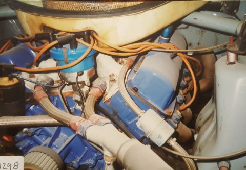1973 Ford Mustang - Close-up of a 1973 Ford Mustang engine bay, blue valve covers and orange spark plug wires.