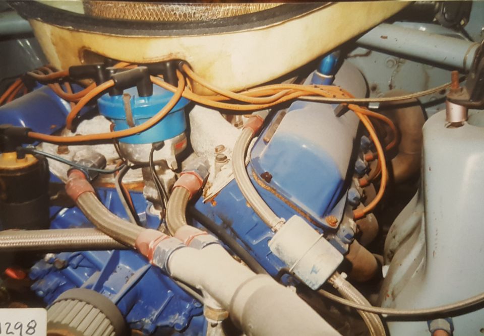 1973 Ford Mustang engine bay with blue valve covers and orange spark plug wires